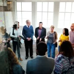 Members of an office gather around to participate in team building activities to strengthen their team